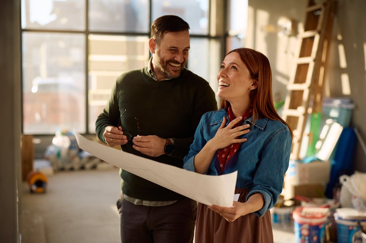A couple reviewing property blueprints together during a home remodeling project